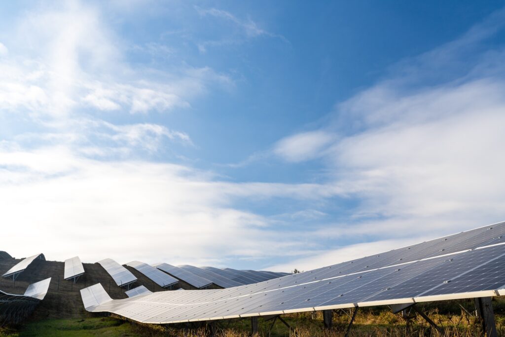 Solar cell panels field. Rows of long sunny batteries on green field.